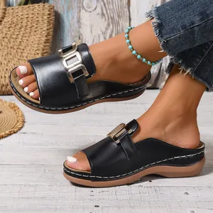 Detailansicht schwarzer Keilsandaletten für Damen mit modischer Metallschnalle und Peep-Toe