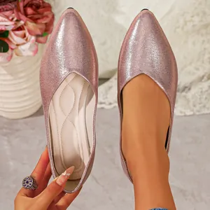 Close-up of pink metallic pointed toe flats with textured fabric and soft insole