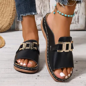 Detailansicht der schwarzen Keilsandalen für Damen mit Metallschnalle und Ziernähten
