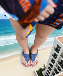 Vue de dessus de tongs compensées bleues avec fleurs pour femmes au bord de la mer