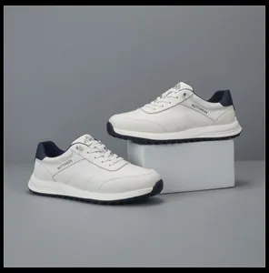 Detailed side view of white leather sneakers with navy accents, thick sole, and lace-up design.