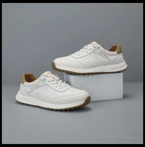 Premium white leather sneakers with brown accents displayed on a minimalist studio pedestal.