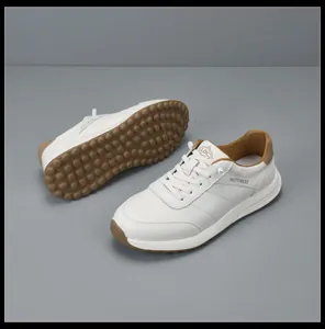 Premium men's white leather sneakers featuring a thick brown sole and traction detail