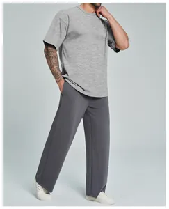 Modelo masculino con camiseta gris de algodón orgánico y pantalones casuales gris oscuro
