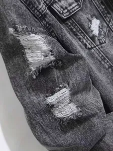 Gros plan détaillé d'une veste en jean grise délavée avec des trous déchirés