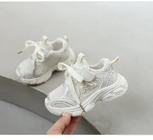 Gros plan de baskets en maille pour enfants de couleur crème avec semelle souple.