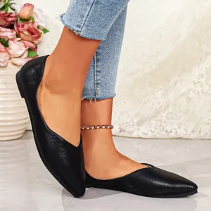 Close-up of black pointed-toe flat shoes with premium textured metallic finish for women