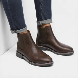 Detailed view of brown retro distressed men's Chelsea boots with elastic side panels.