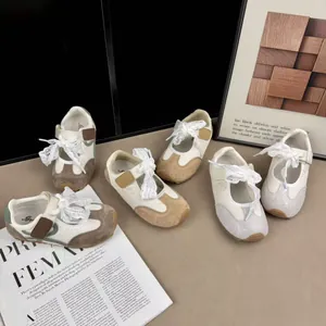 Detail view of retro kids sneakers with cream-brown color blocking and soft soles.