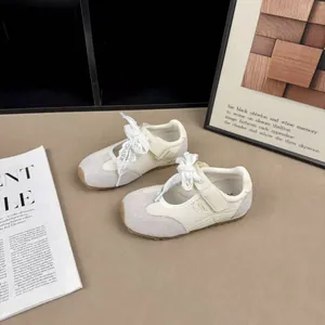 Close-up of breathable mesh kids' cream Mary Jane sneakers with lace ribbon detail
