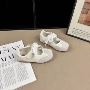 Close-up of beige mesh children's sneakers with lace ribbon details on magazine
