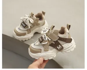 Close-up of children's chunky sneakers in beige and brown with anti-slip thick soles.