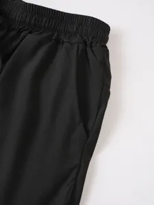 Detalle de pantalones cortos deportivos negros para hombre con cintura elástica y bolsillo