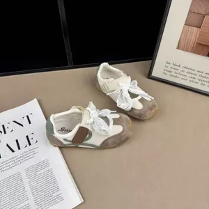Detail view of kids mesh sneakers with suede overlays and ribbon laces