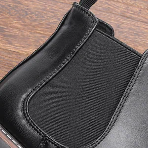 Close-up detail of black leather Chelsea boot with elastic side panel and stitching