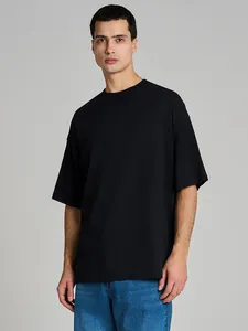 Detailed texture view of a heavy cotton black oversized men's t-shirt on a studio model