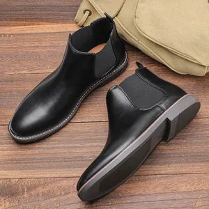 High-angle view of classic men's black leather Chelsea boots with elastic side panels