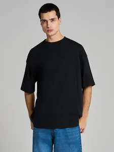 Upper body detail of a heavyweight black cotton oversized t-shirt on a male model