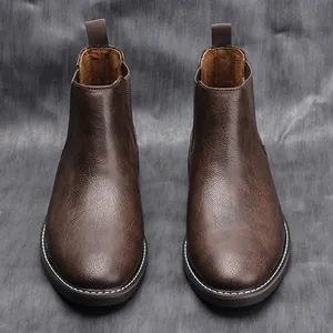 Detail view of retro dark brown men's Chelsea boots with textured leather and contrast stitching