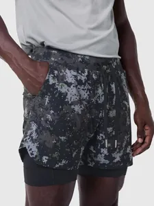 Detalle de pantalones cortos de running de doble capa para hombre con camuflaje digital.