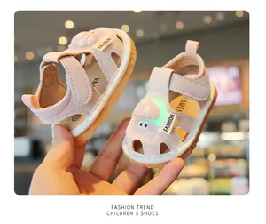 Detail view of pink toddler sandals featuring glowing cartoon lights and Velcro straps