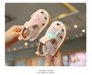 Close-up of pink toddler sandals featuring a glowing green LED and cute cartoon animal design