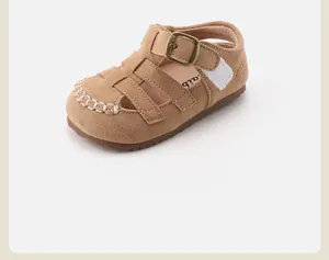 Detail view of retro brown suede toddler sandals with hollow closed-toe and metal buckle.