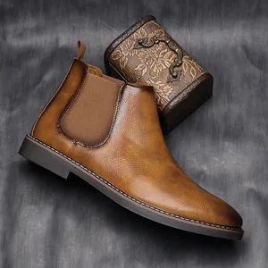 Side view of vintage brown leather Chelsea boots for men with elastic side panel detail.