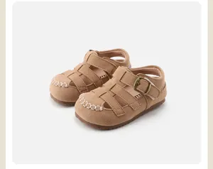 Close-up of retro brown children's Roman sandals featuring a hollow design and soft sole.