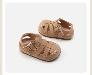 Detailed view of camel suede children's Roman sandals with a soft sole buckle