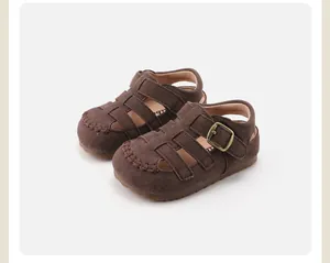 Detailed view of brown suede children's Roman sandals with closed-toe hollow design