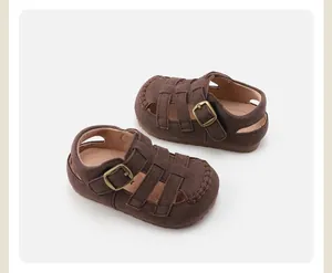 Detailed view of brown suede kids' leather Roman sandals with retro buckle closure.
