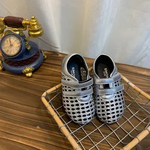 Detailed view of silver woven hollow-out Mary Jane shoes with mesh design and Velcro straps