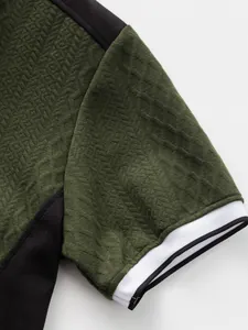 Détail de la texture jacquard vert olive et du bord-côte blanc sur un t-shirt décontracté