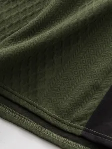 Détail en gros plan du tissu jacquard vert texturé et des coutures de qualité