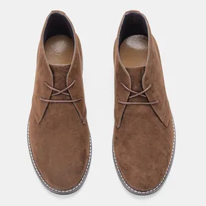 Vue de dessus de bottines désert pour hommes en daim marron avec coutures blanches