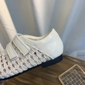 Close-up of woven mesh Mary Jane sandals with white leather and Velcro strap detail