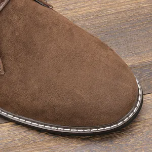Détail macro d'une bottine désert en daim marron avec coutures et texture