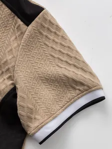 Gros plan sur le motif jacquard texturé et le revers rayé d'un t-shirt pour homme