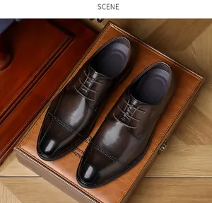 Detail showing polished brown men's leather business shoes with brogue pattern