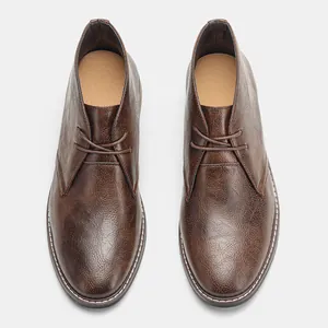 Vue de dessus de bottines de désert en cuir marron pour hommes avec lacets classiques
