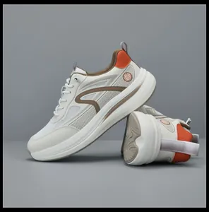 Dettaglio scarpe sportive in rete bianca traspirante con inserti arancioni e suole alte.
