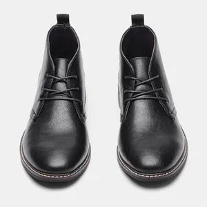 Vue frontale professionnelle de bottines désert noires en cuir texturé pour hommes avec lacets