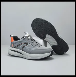 Profilo laterale e suola esterna ondulata di sneaker da uomo grigie e traspiranti