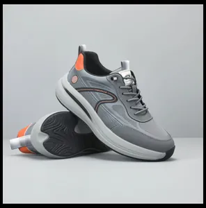 Vista dettagliata di sneakers in mesh grigio traspirante con dettagli arancioni e suola spessa