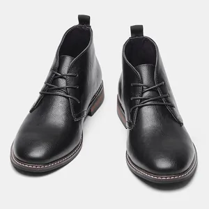 Vue de face de bottines chukka classiques noires pour hommes avec semelle brune