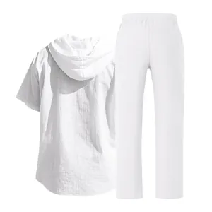 Dettaglio posteriore di camicia con cappuccio in lino bianco e pantaloni con vita elastica