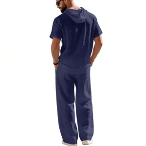 Vista posteriore di un uomo con camicia di lino blu navy con cappuccio e pantaloni.