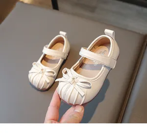 Close-up of elegant cream girls' Mary Jane leather shoes with a delicate bow knot