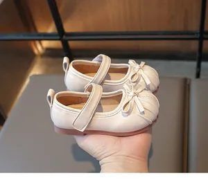 Close-up of beige Mary Jane shoes for girls featuring a bow and pleated toe design